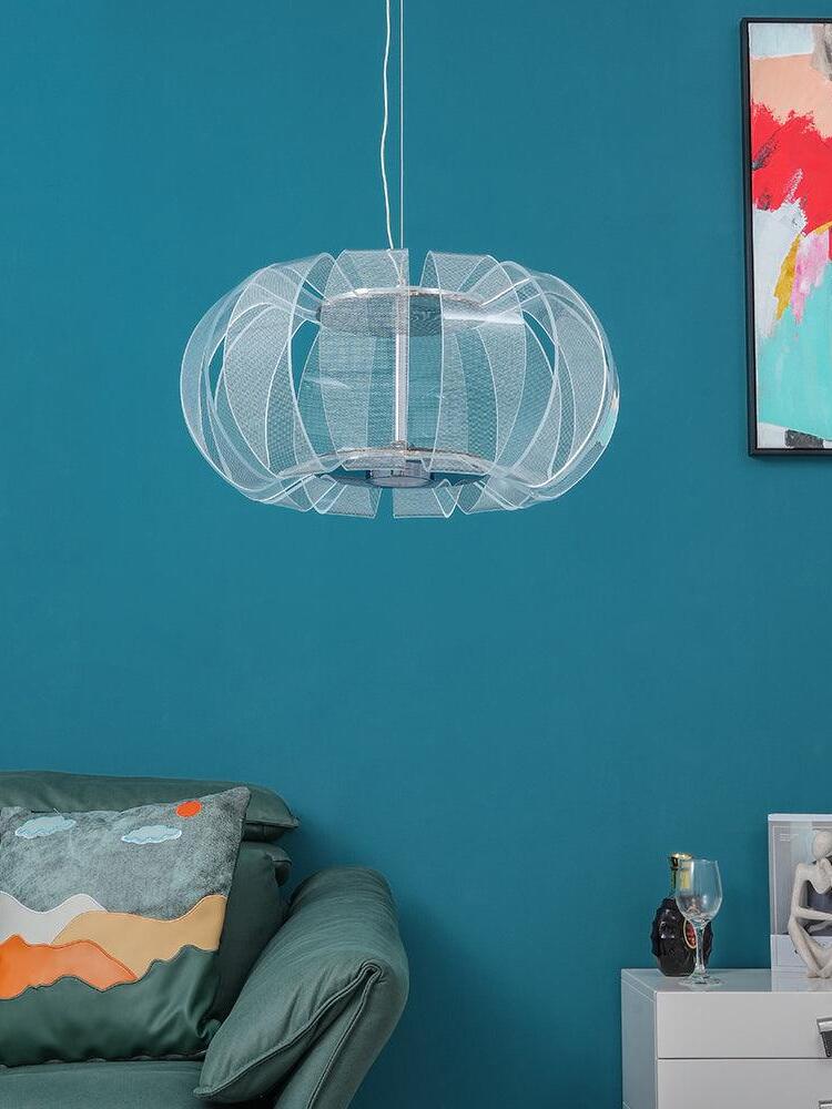 Clear ribbed oval pendant beside a teal wall, green sofa and framed artwork