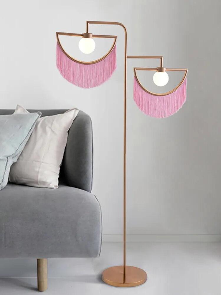 Wink pink fringed floor lamp beside a sofa