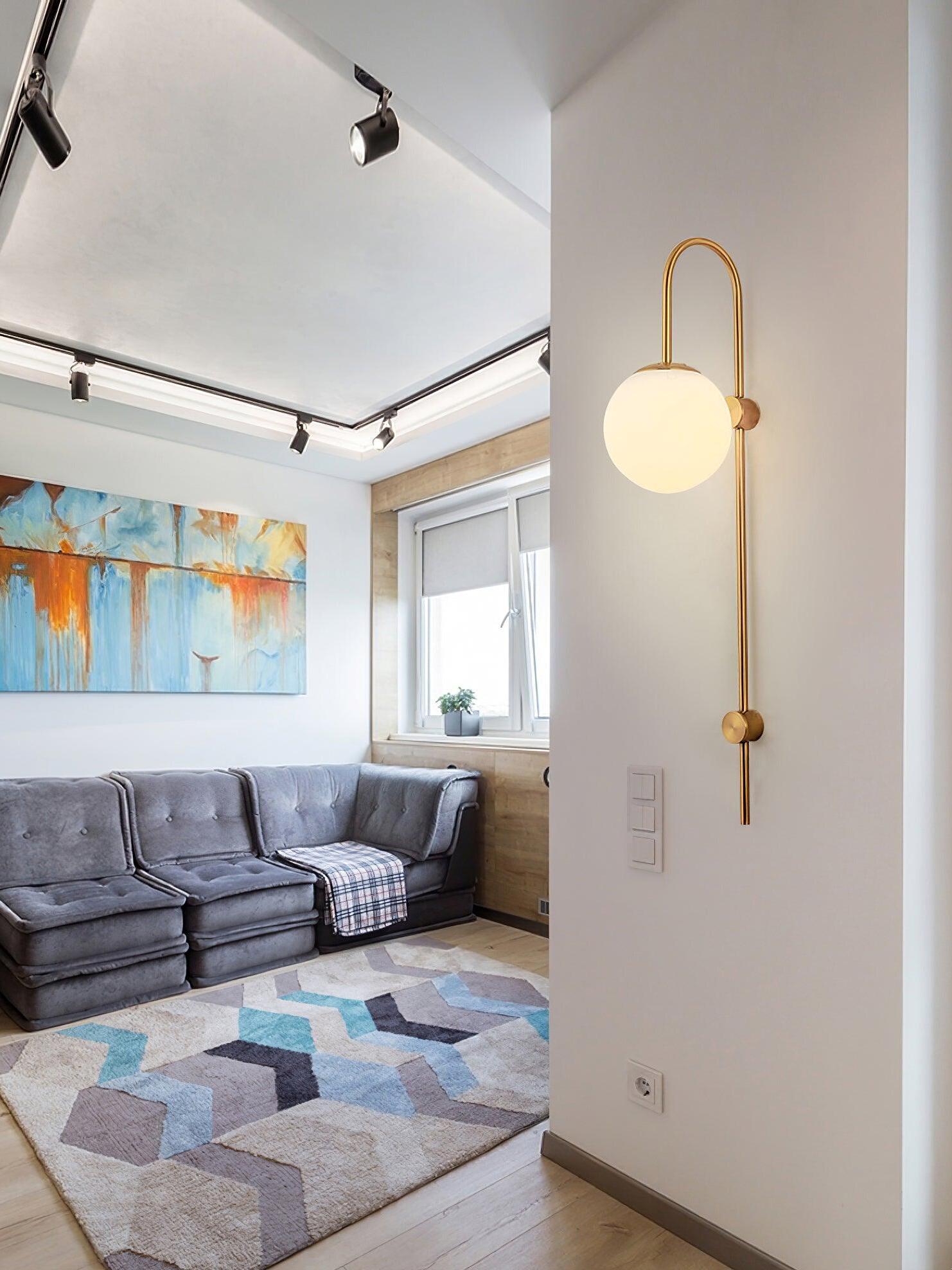 Gold globe sconce on living room partition wall