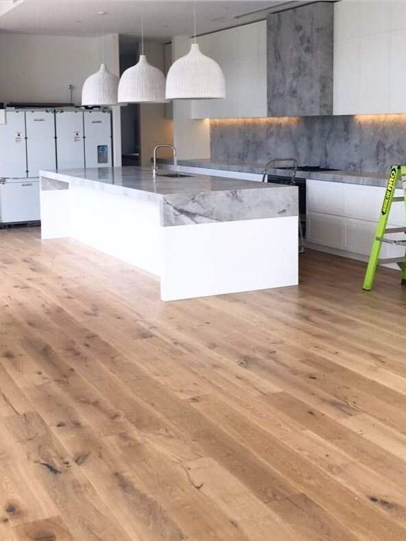 Three pale woven pendants above a white kitchen island