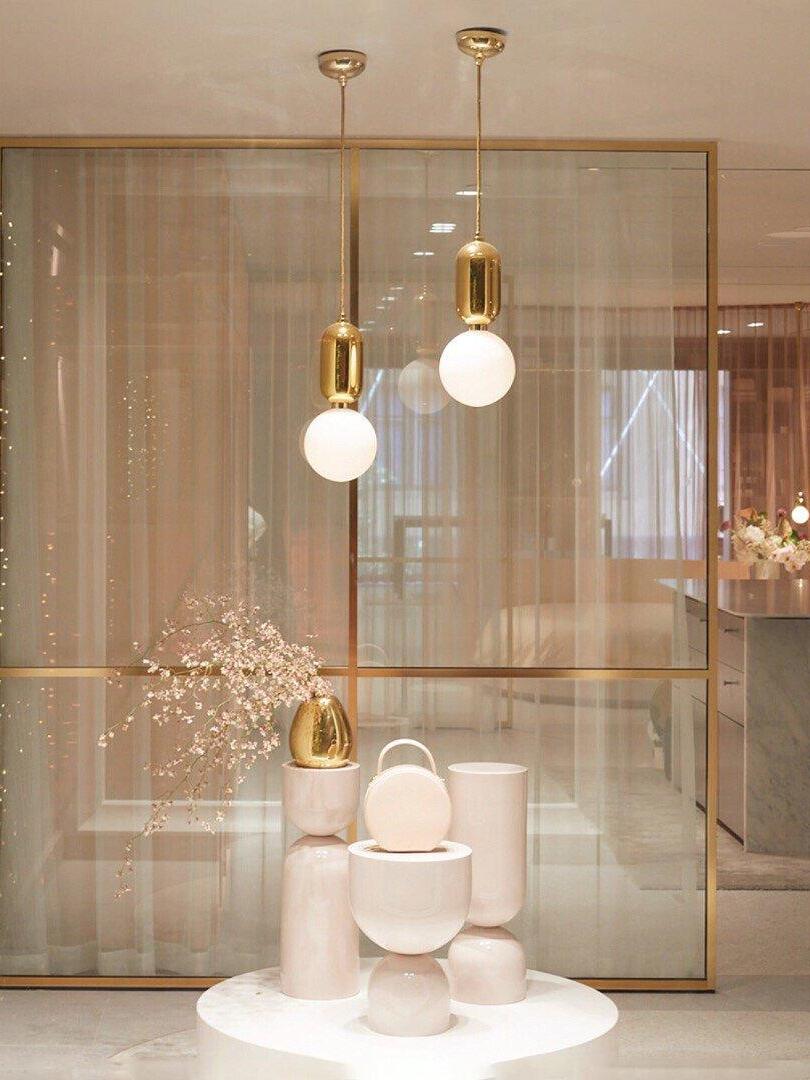 Two reflective-cap globe pendants above a sculptural white pedestal