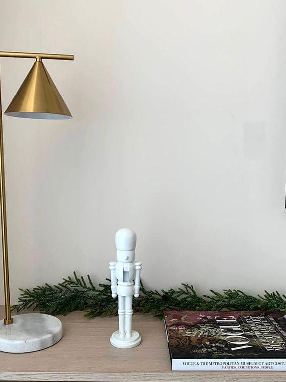 Cropped gold-tone lamp on console beside figurine and books