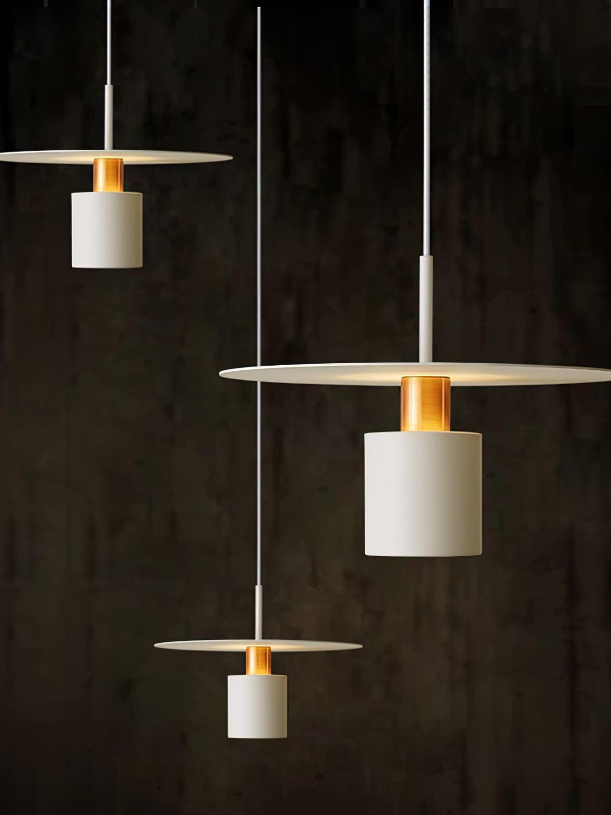 Three white disc pendants above dark table