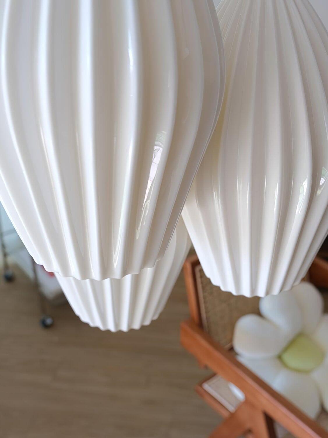 Close-up of two white ceramic shades showing their sculpted vertical ribs