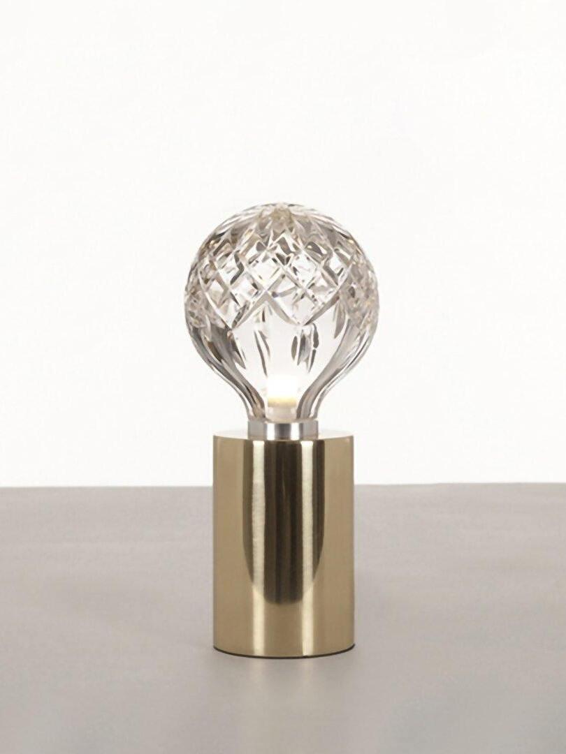 Patterned clear globe table lamp on pale surface