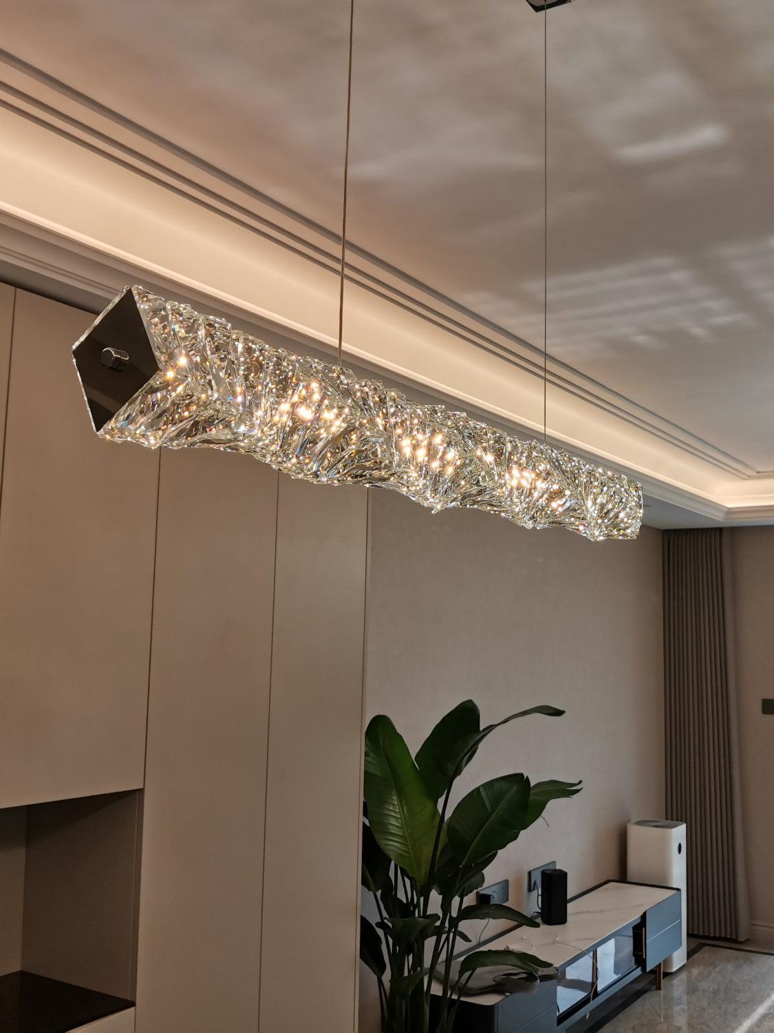 Gold end plate and faceted crystal bar seen diagonally near white kitchen cabinets