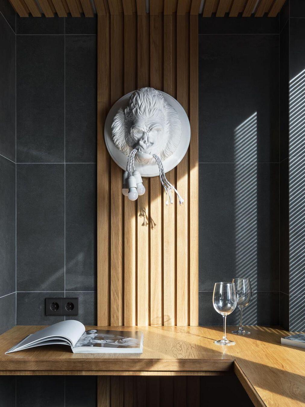 White gorilla head between vertical wood strips above table with open book