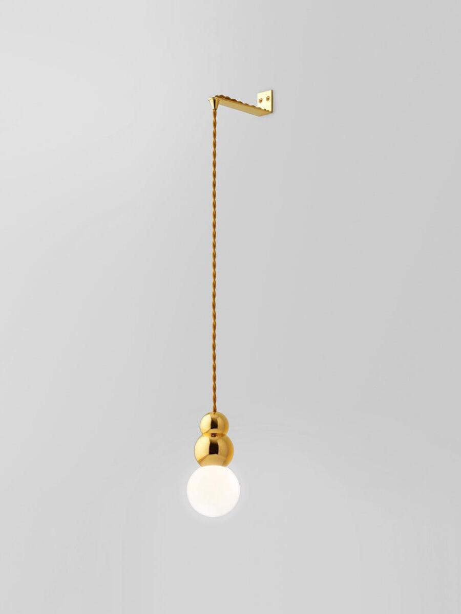 Gold Flex wall light with larger glowing round bulb