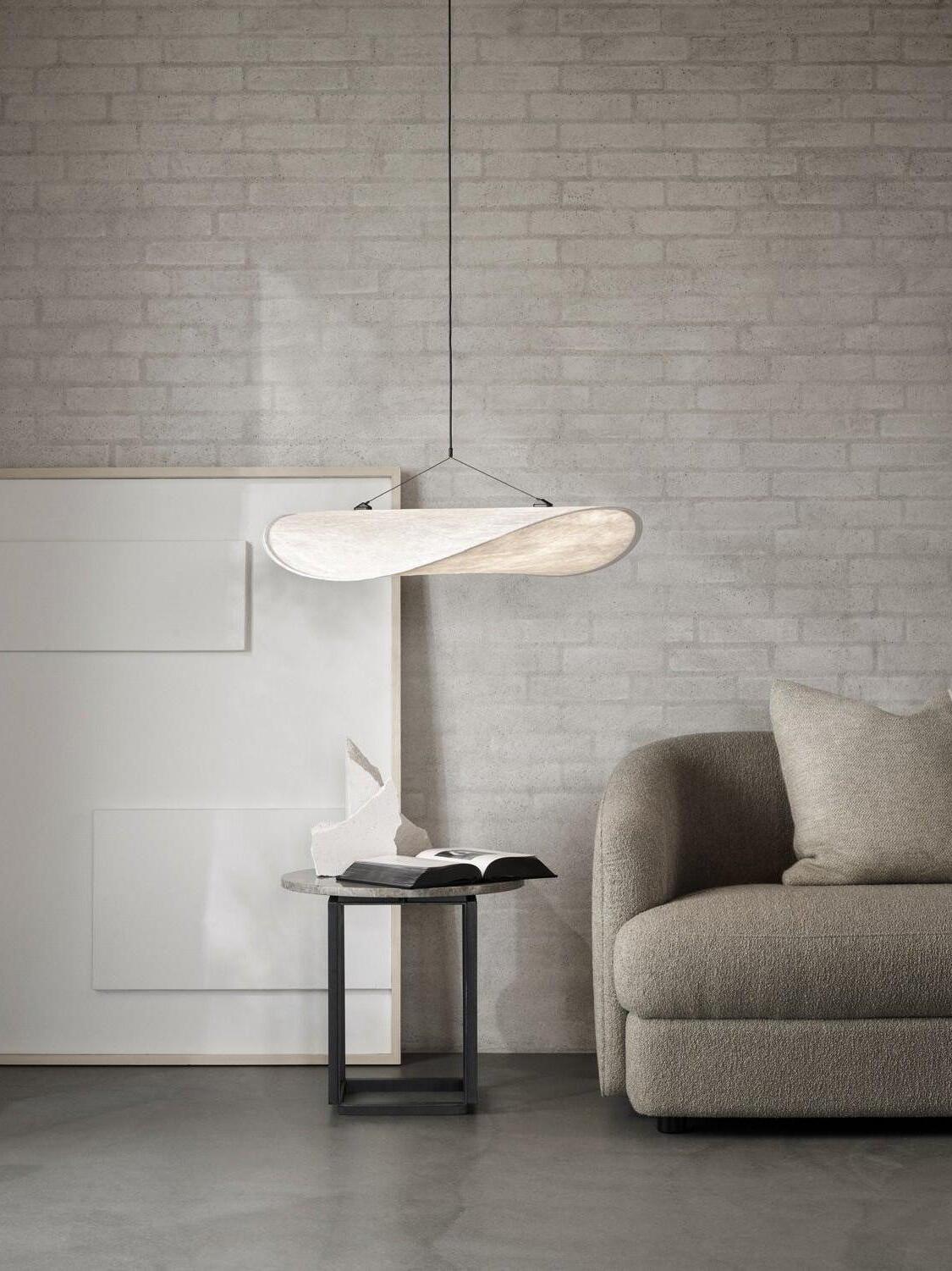 Small white pendant beside a gray armchair