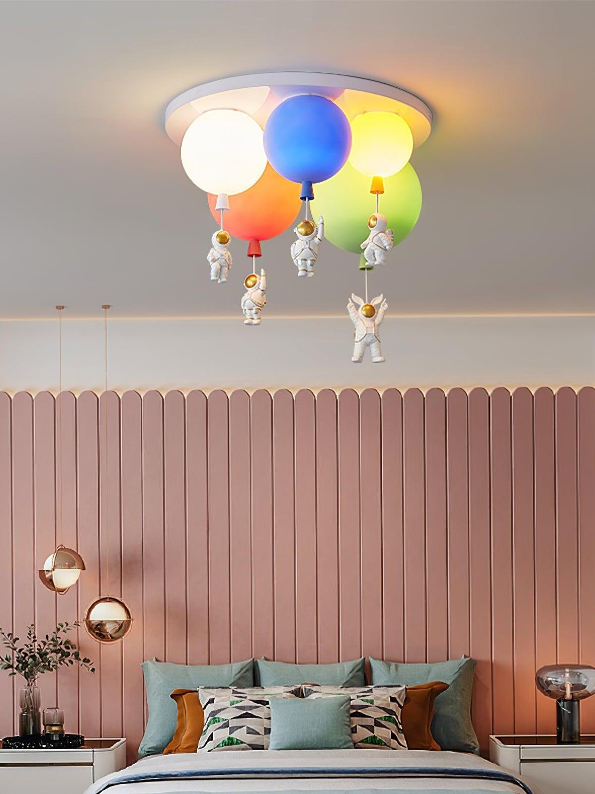 Colourful balloon light above a pink panelled headboard