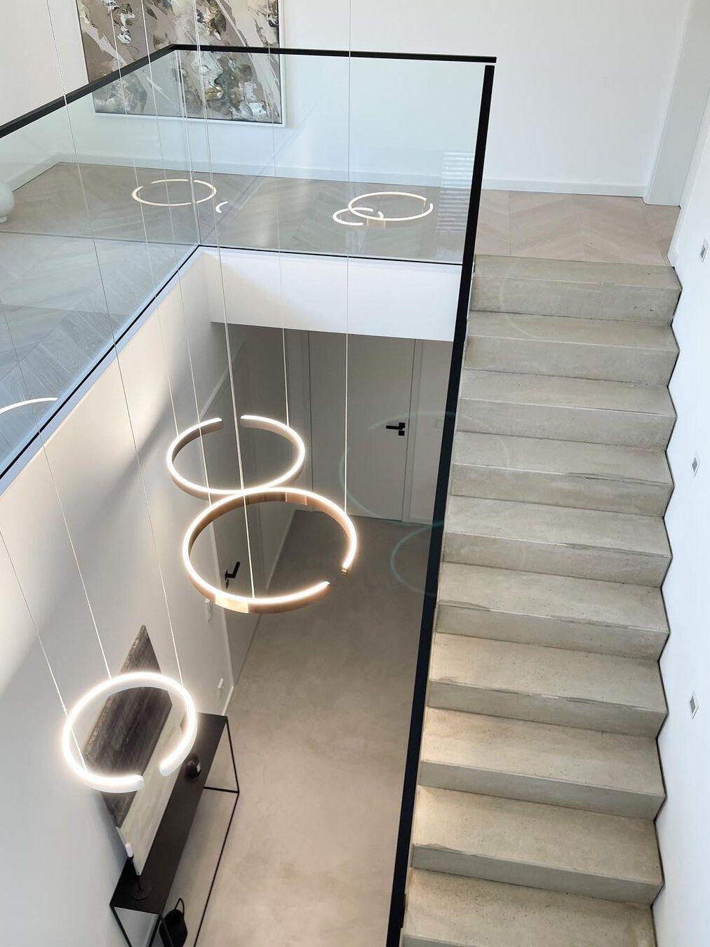 Ring lights suspended beside a staircase