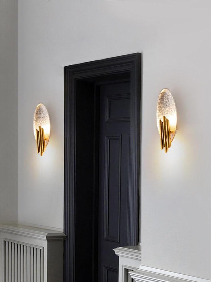 Paired silver-tone oval wall lights with gold tubes flanking doorway