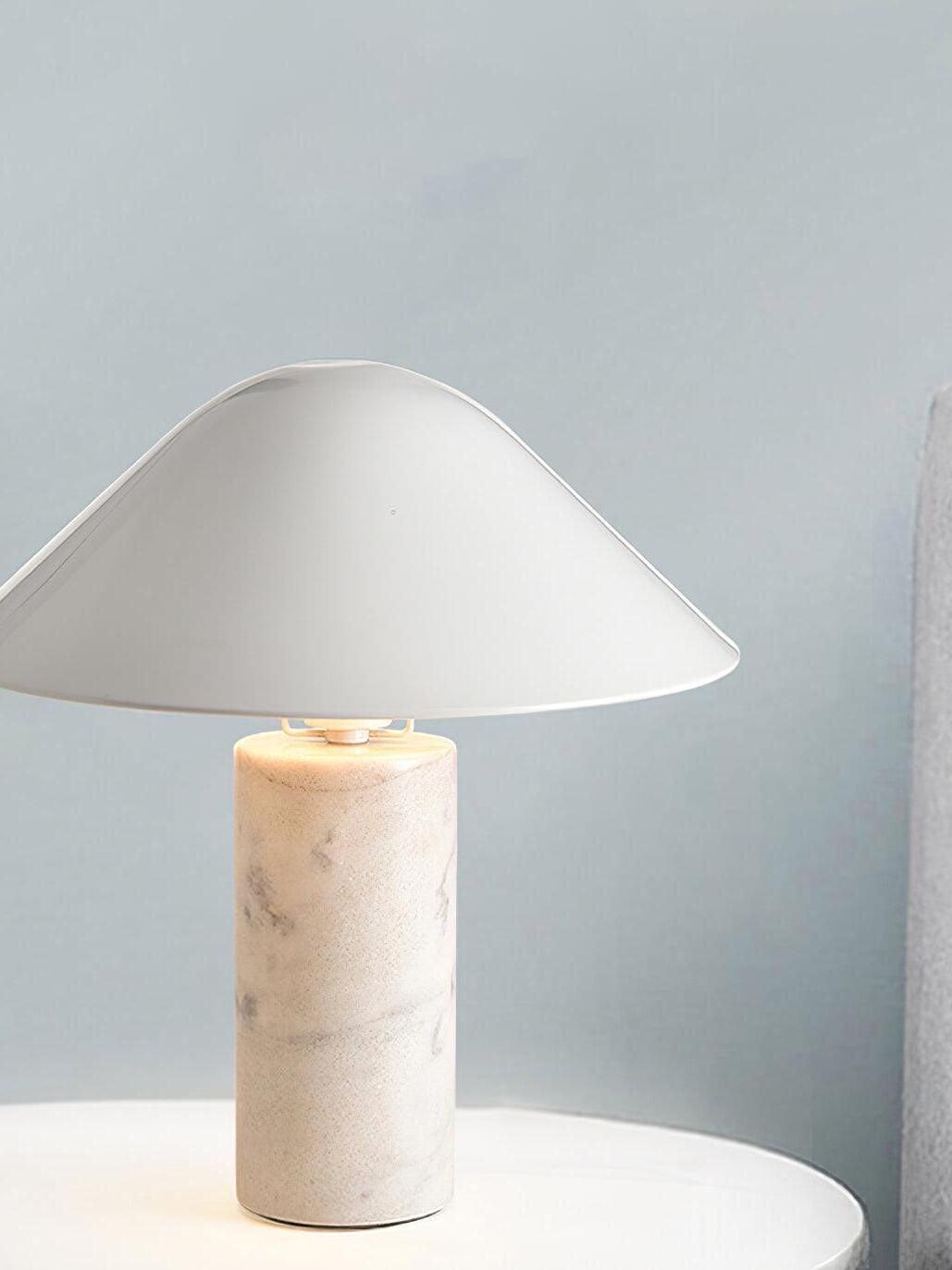 Lit white cone-shade lamp with pale marble base