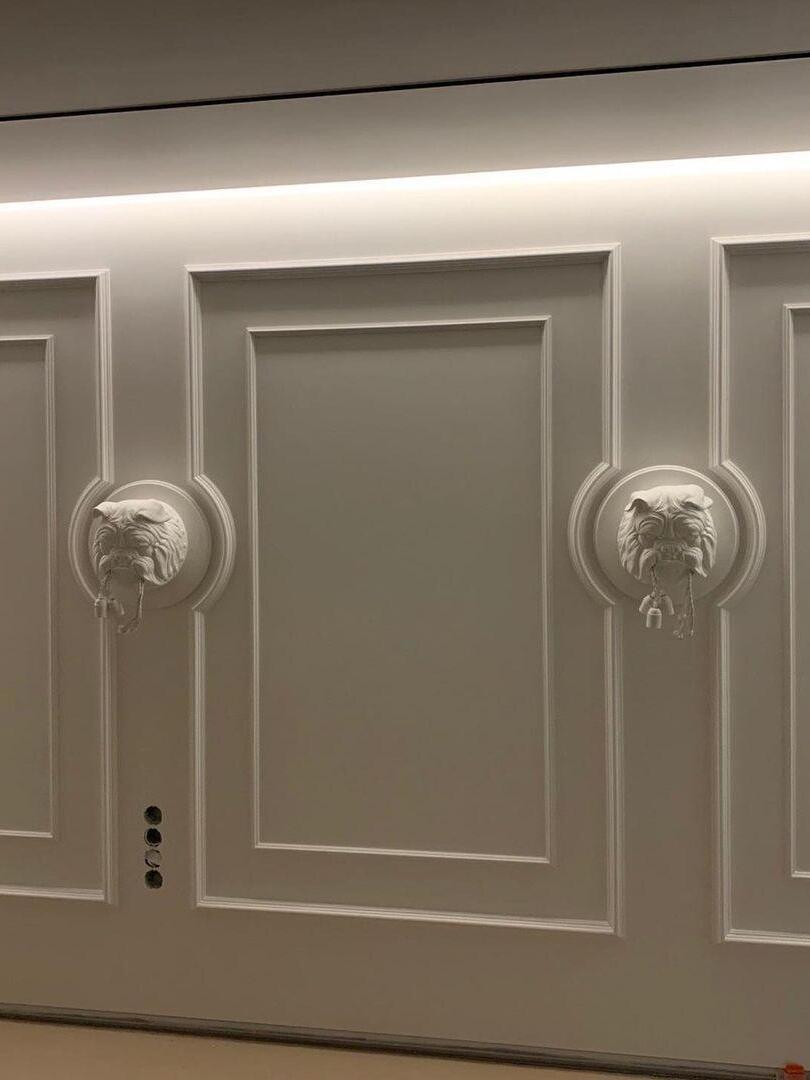 Paired white bulldog fixtures on a moulded wall