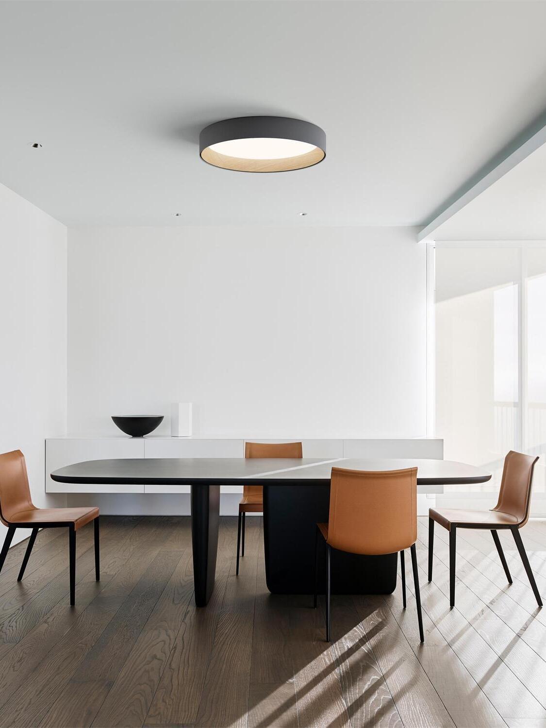 Black round ceiling light over dining table