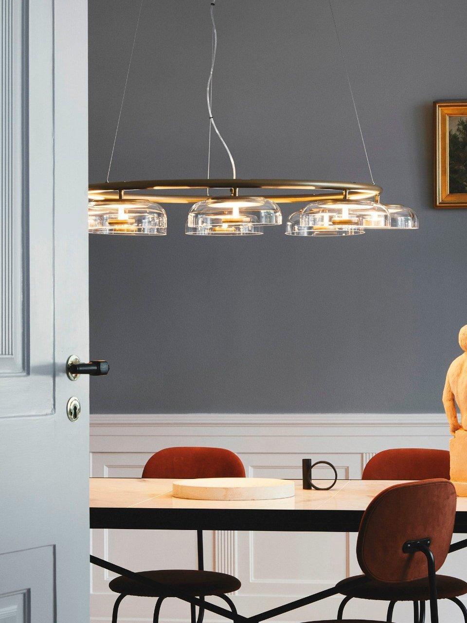 Side view of the illuminated glass chandelier above a table