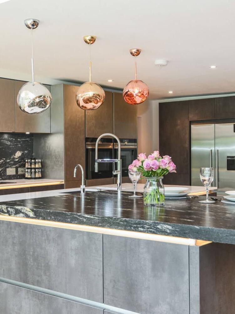 Mixed metallic-looking pendants above a kitchen island