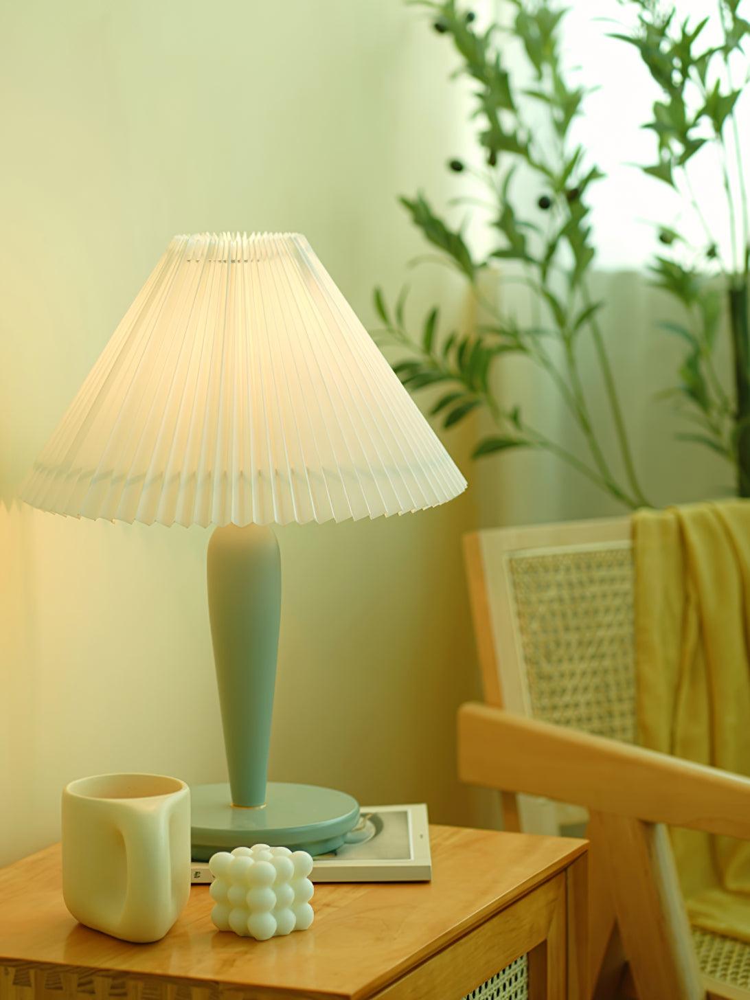 Light-blue pleated-shade lamp beside wooden chair