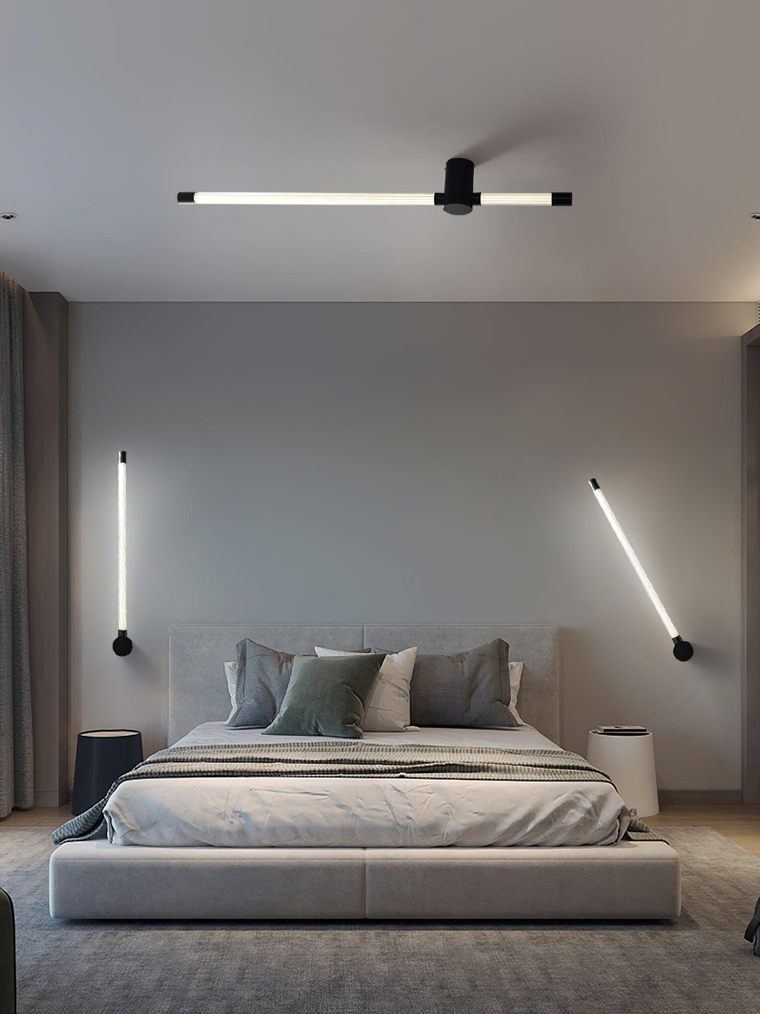 Black tube fixtures displayed vertically, at an angle and horizontally around a bed