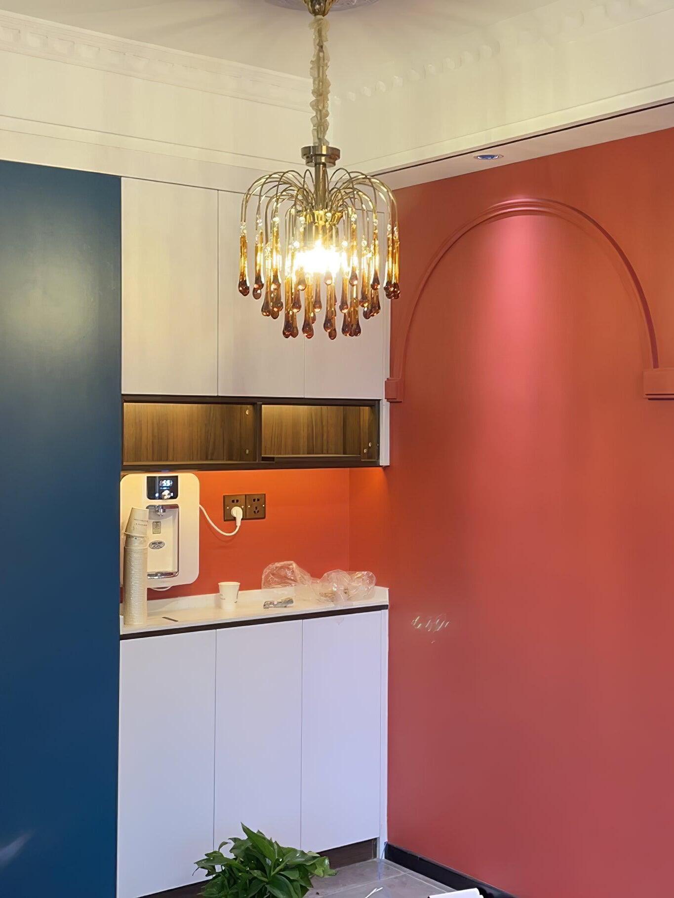 Crystal chandelier near a colourful kitchen wall