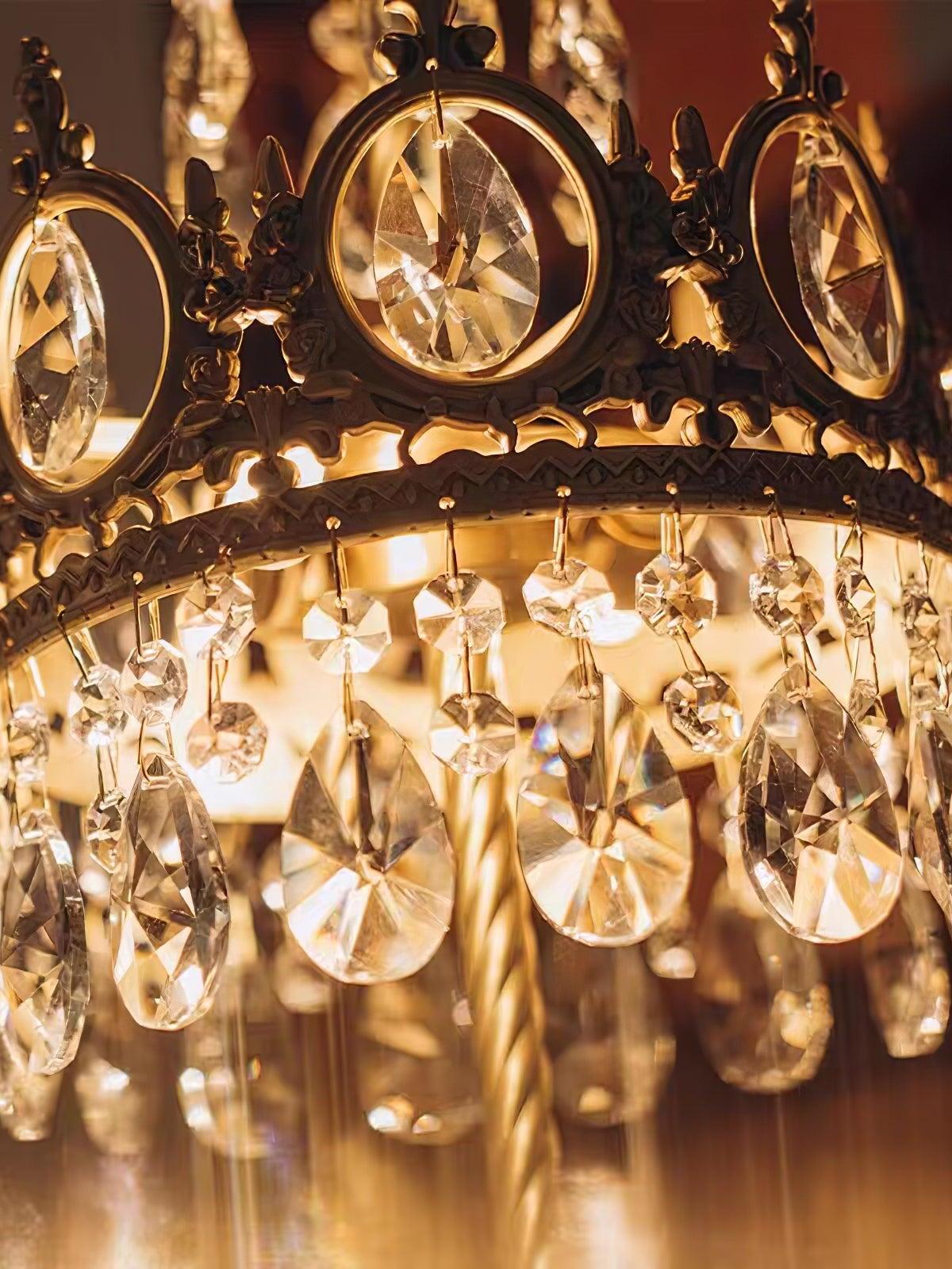 Close-up of a lit oval crown crystal and the teardrop fringe below the decorative metal band.