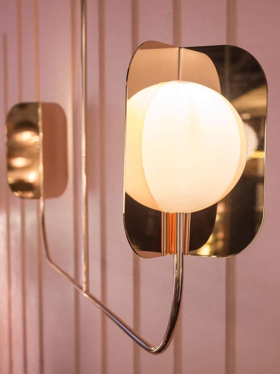 White rounded light element and rose-gold-coloured leaf shield