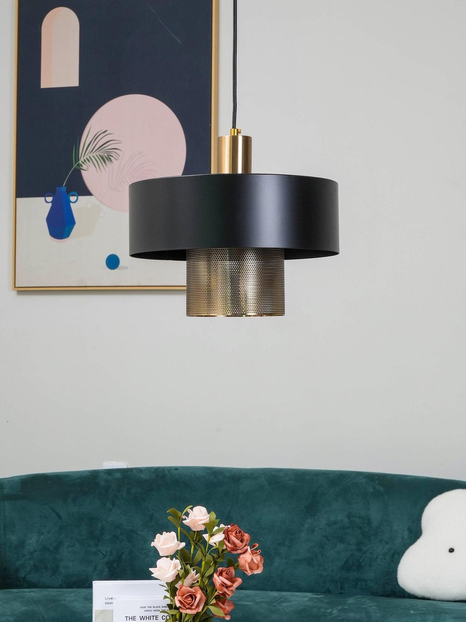 Bradbury black pendant beside abstract artwork above a teal sofa, with flowers on the table below