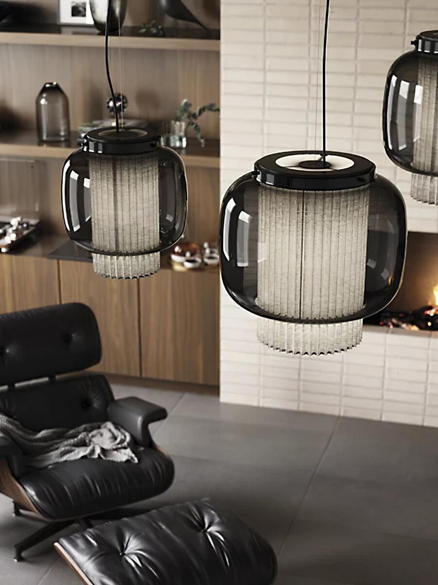 Manila T pendant-light group beside a black leather lounge chair, shelves and a white brick fireplace