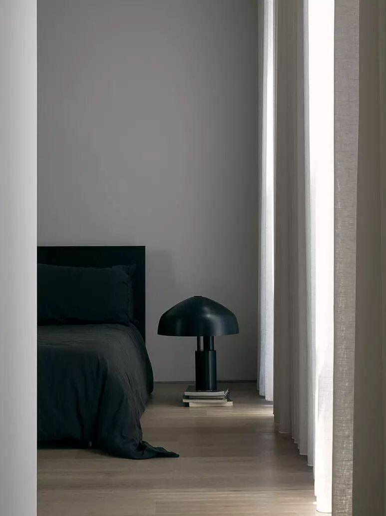 Black dome lamp on low table in bedroom