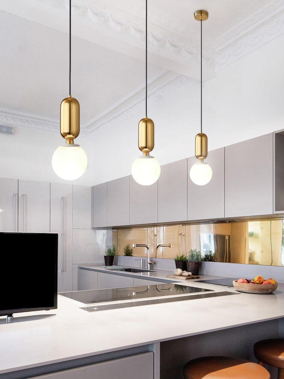 Three pendants with reflective caps above a kitchen island