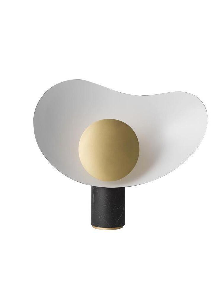 Isolated white curved table lamp with gold disc and short-looking black base
