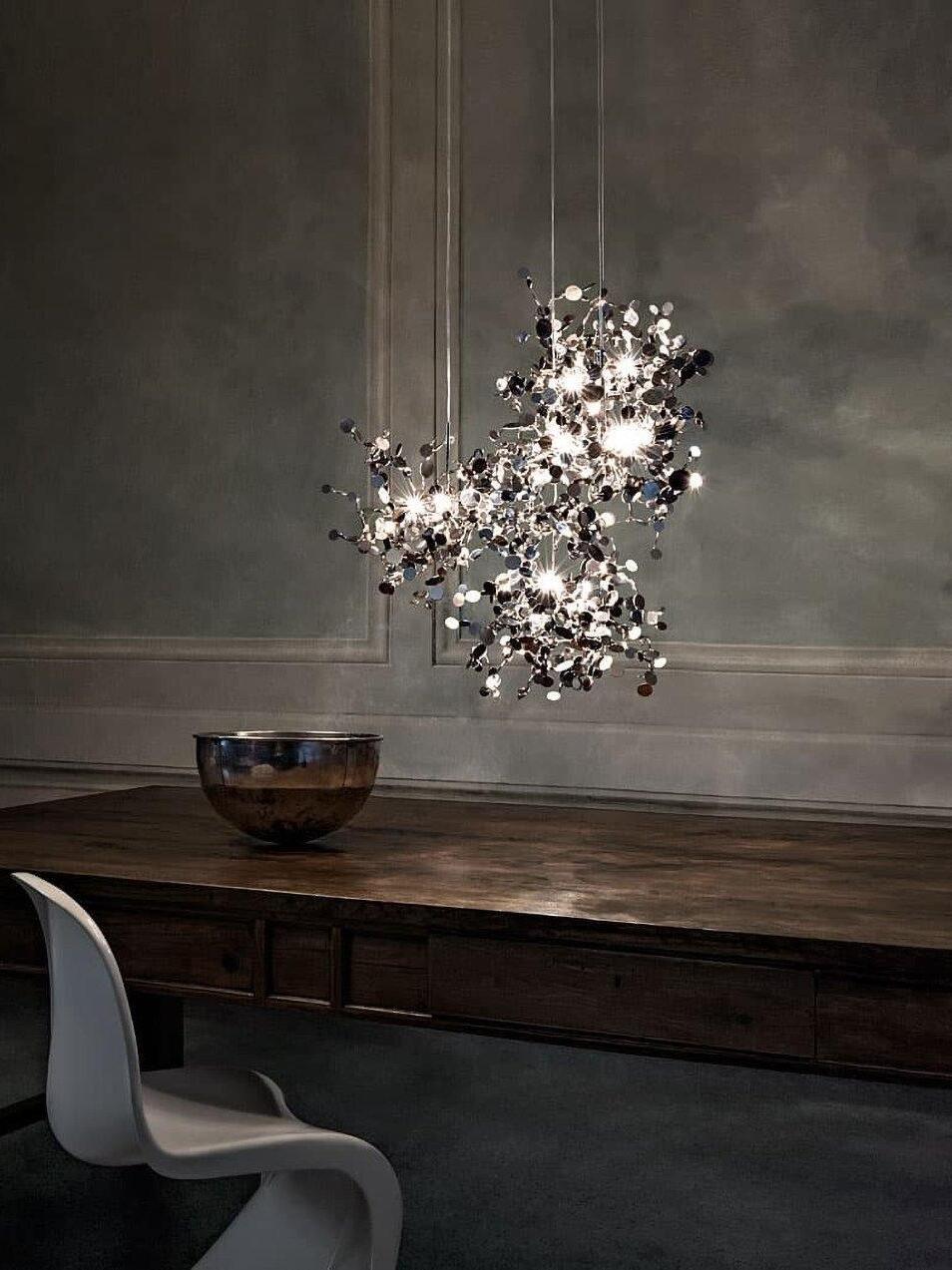 Silver suspended disc cluster above a dark sideboard