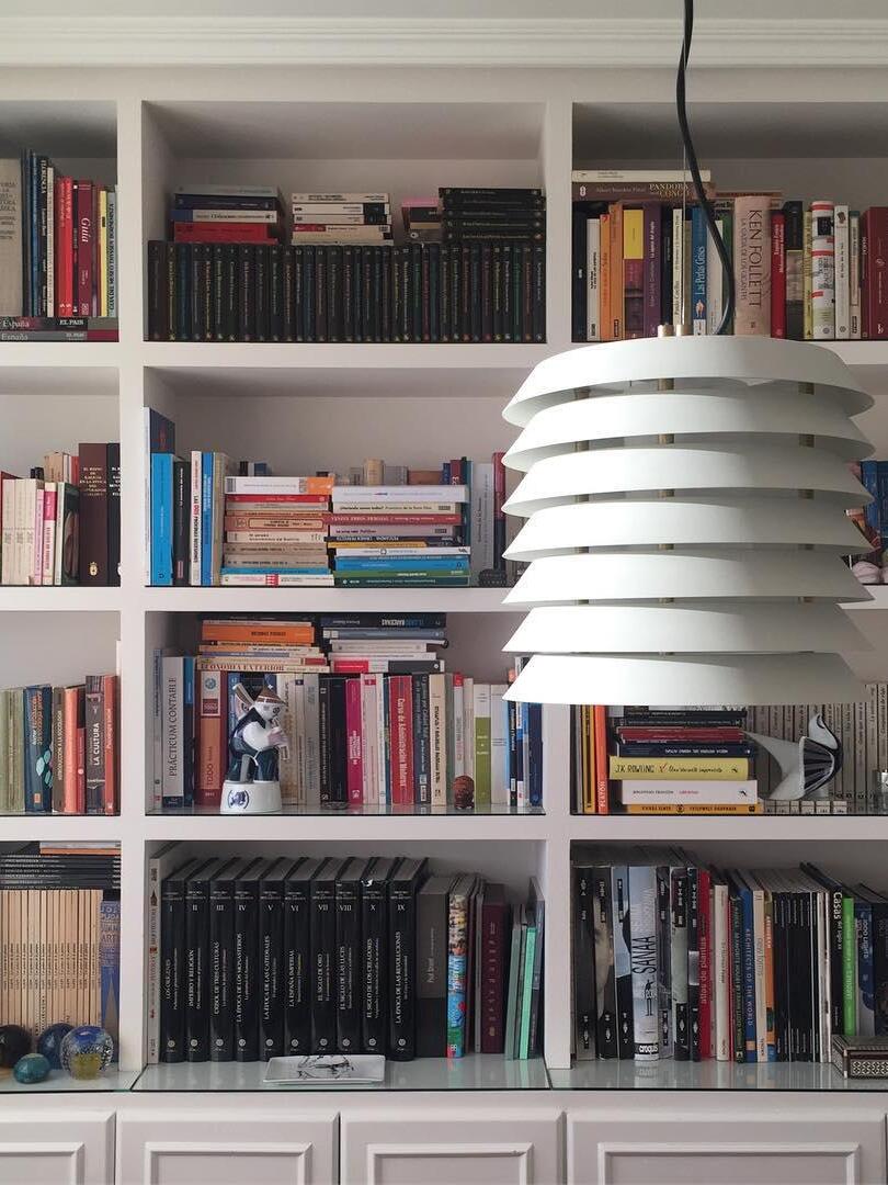 White layered pendant hanging in front of filled bookshelves