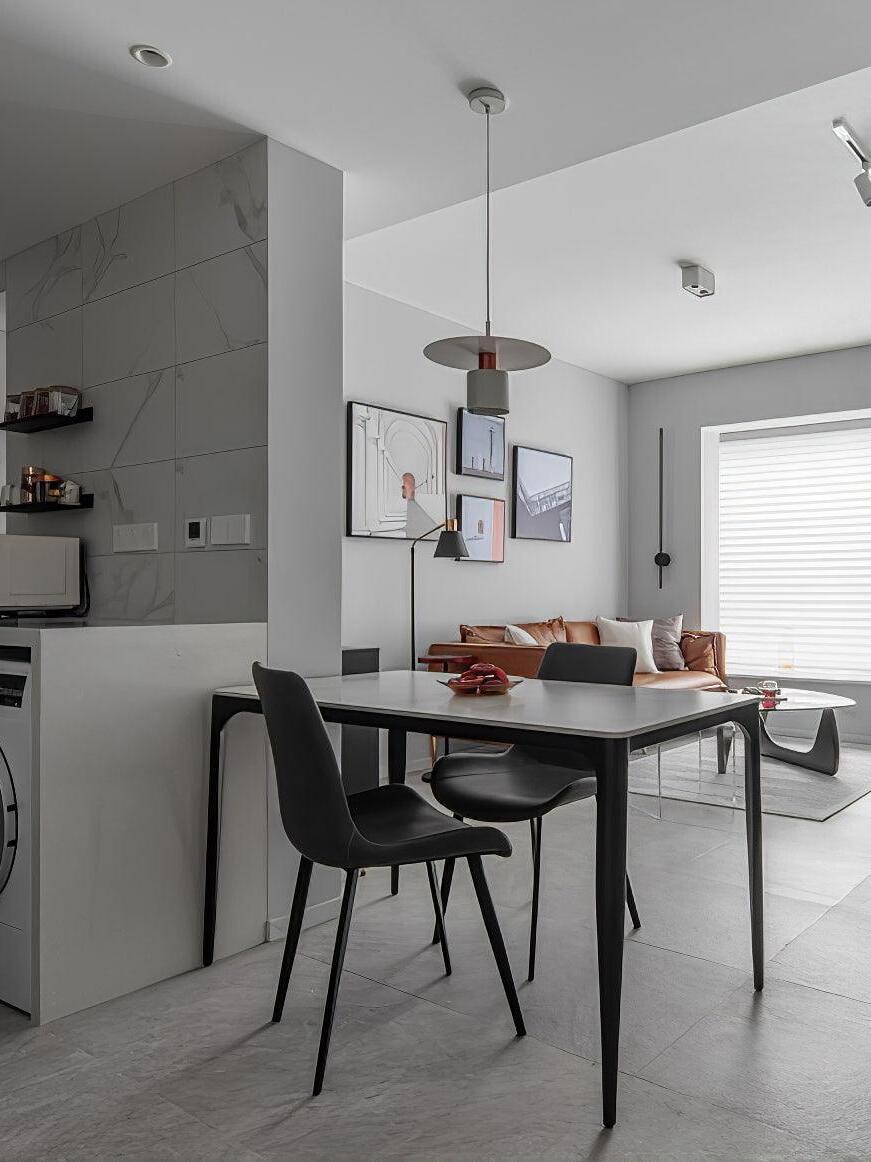 Black disc pendant above black dining table