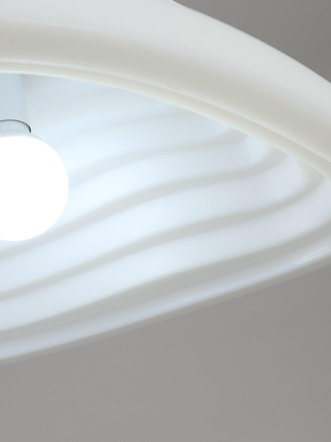 Close-up of an illuminated bulb and the layered white inner shade surface.