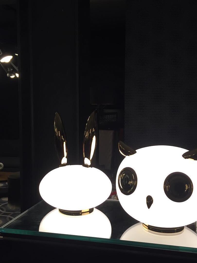 Lit rabbit and owl on dark reflective counter in close view
