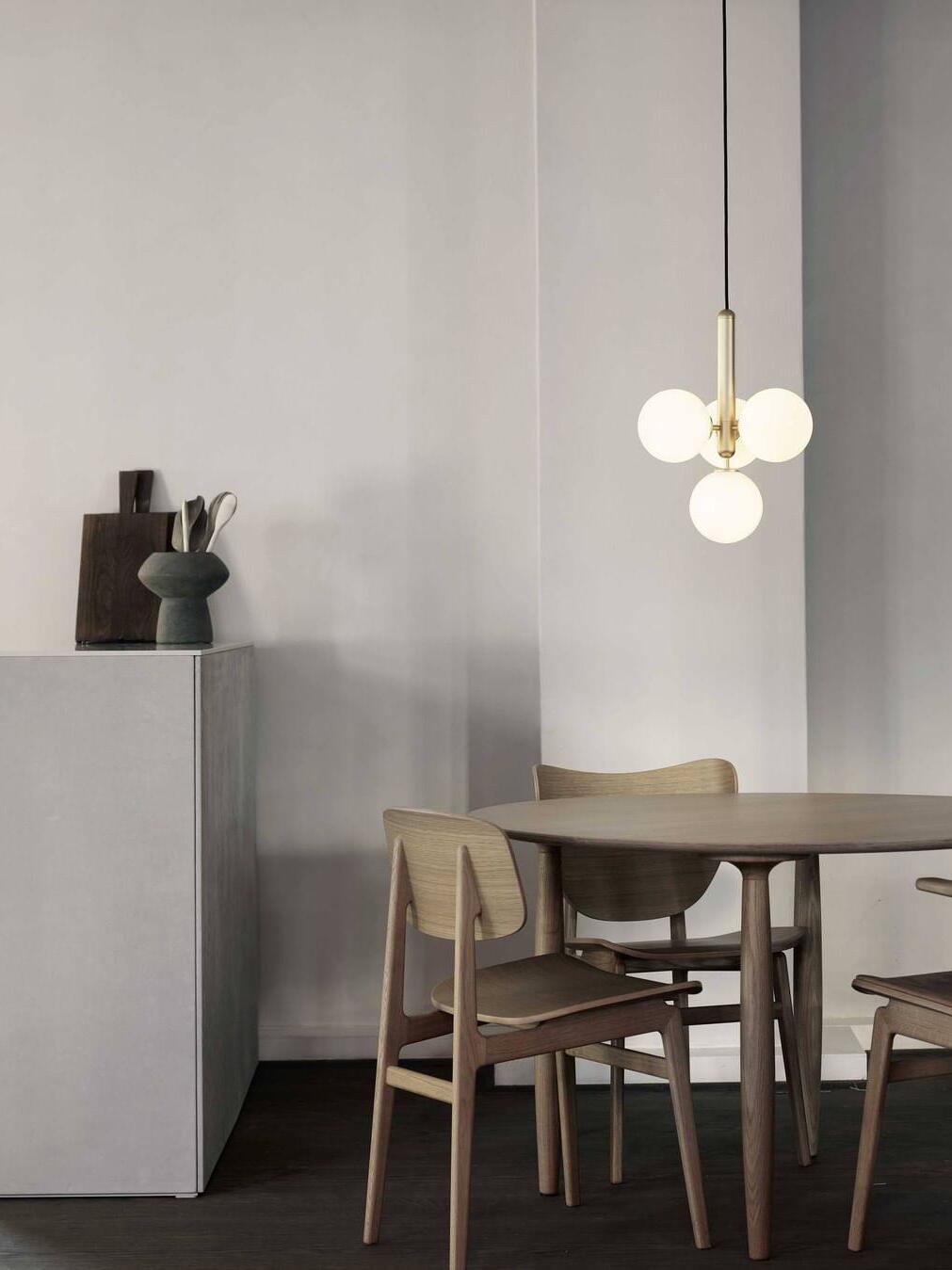 White-globe cluster over a minimal dining table