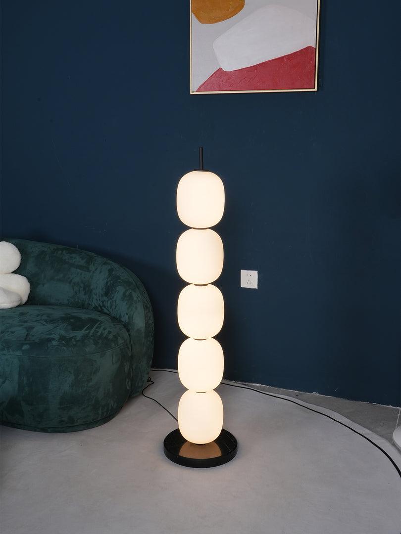 Five-globe lamp on round base against blue wall