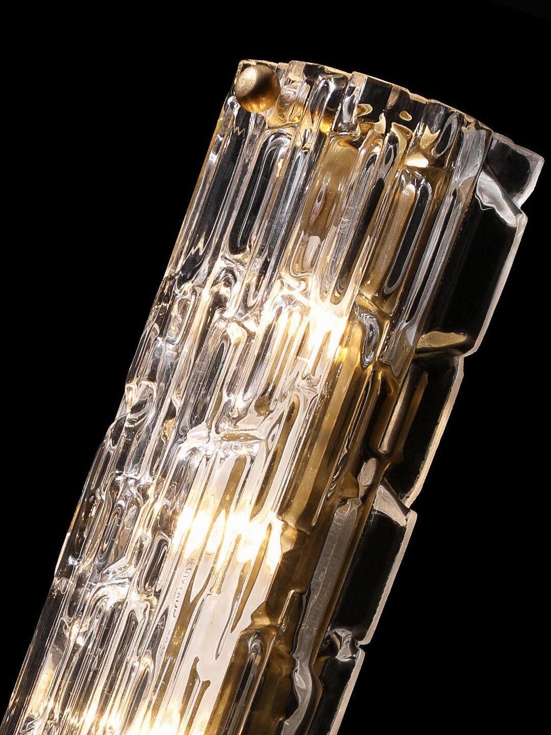 Clear glass relief and gold-tone fastener in close detail