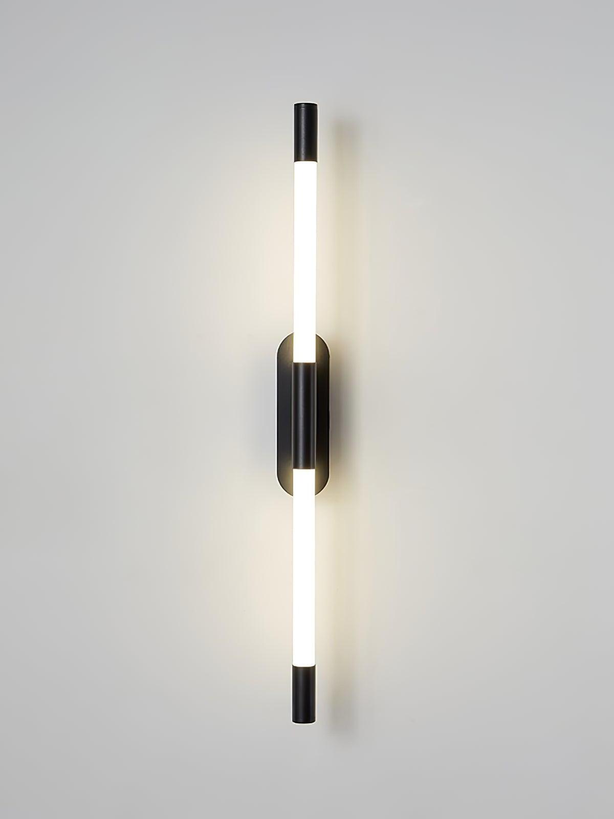 Front view of the glowing black Agnes wall light with two white tube sections and black end caps