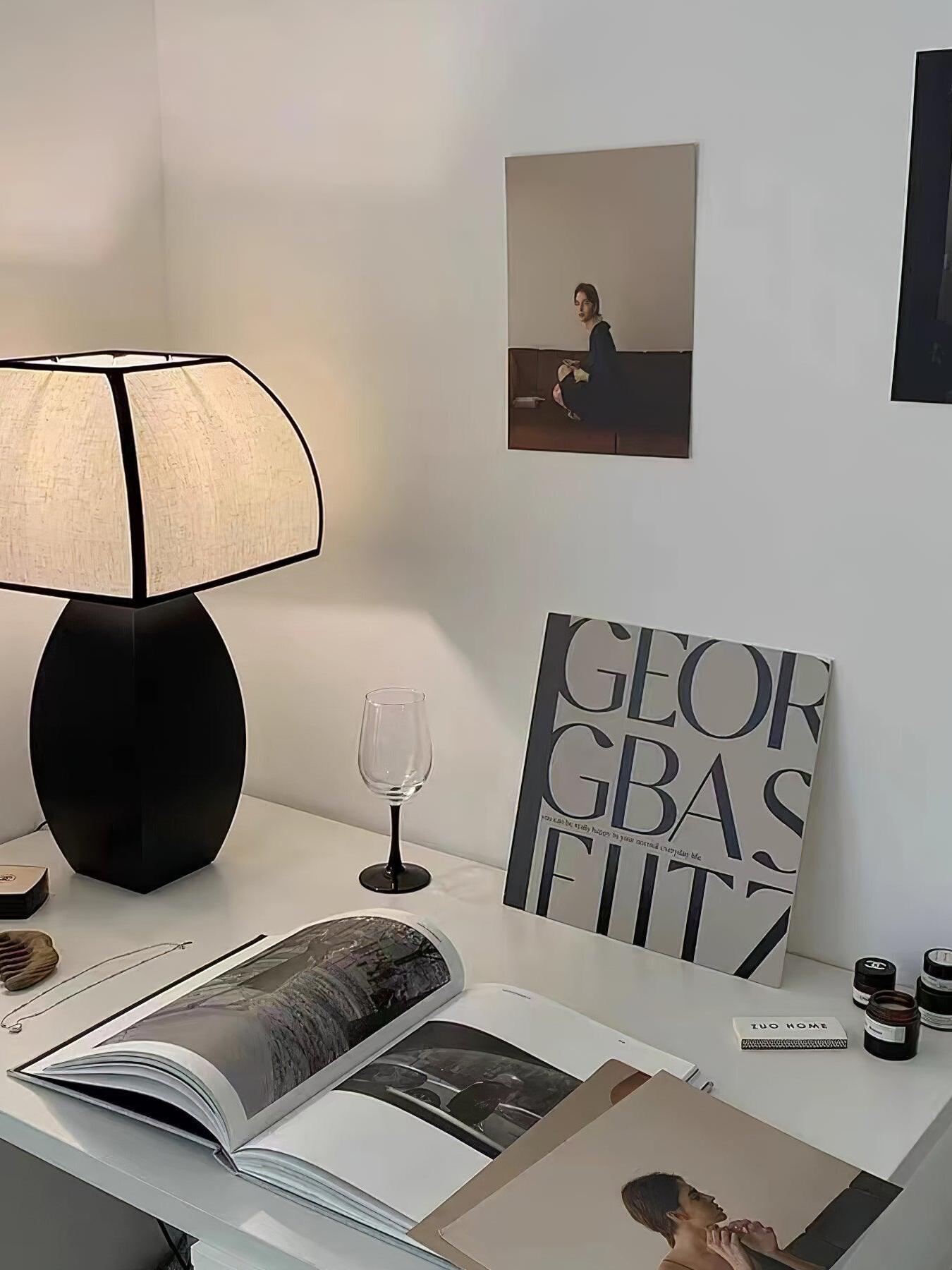 Black Javier table lamp on white desk beside book