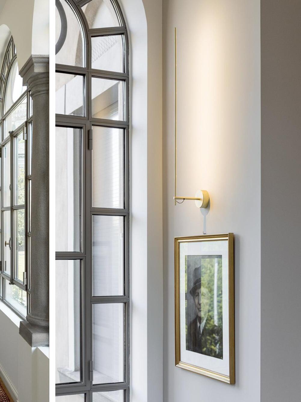 Light Stick V beside a tall window and framed art
