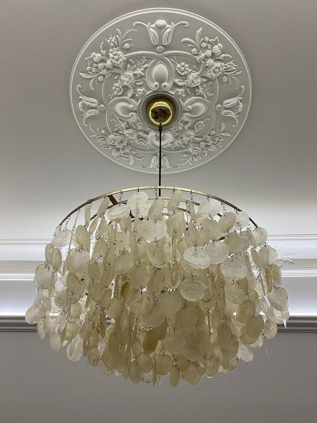 White shell disc chains below a ceiling rose