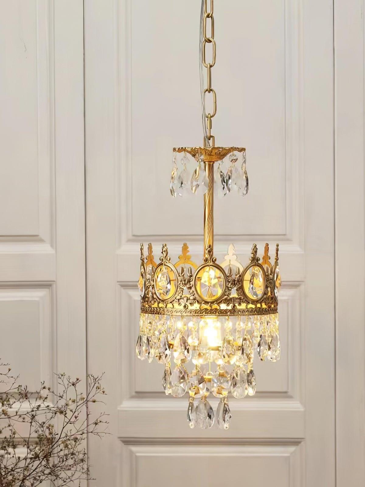 Illuminated crystal chandelier with a narrow crown and upper drop-trimmed disc against white wall panels