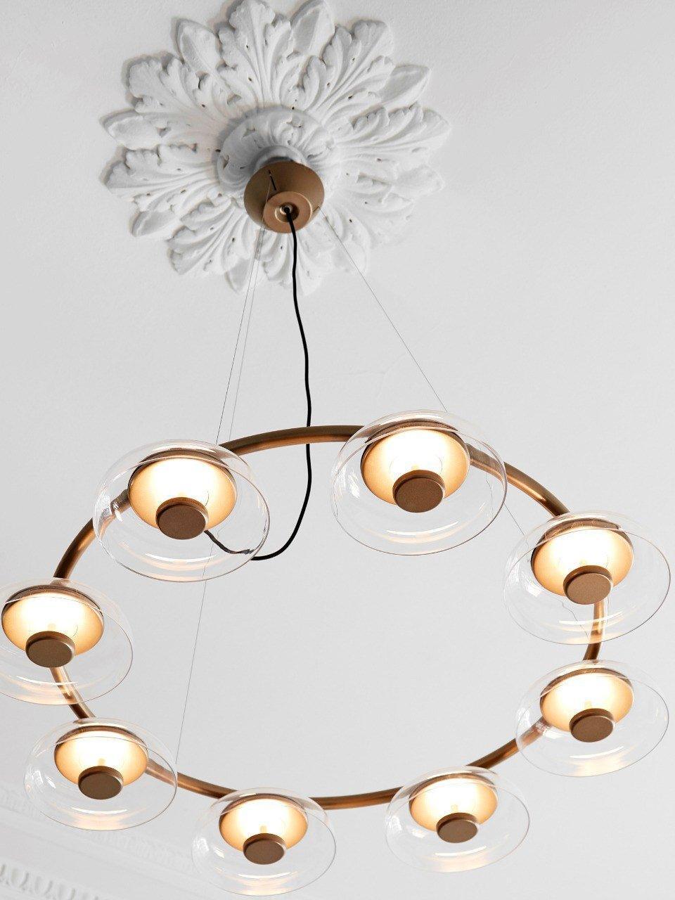 Upward view of the glowing glass shades around the gold ring