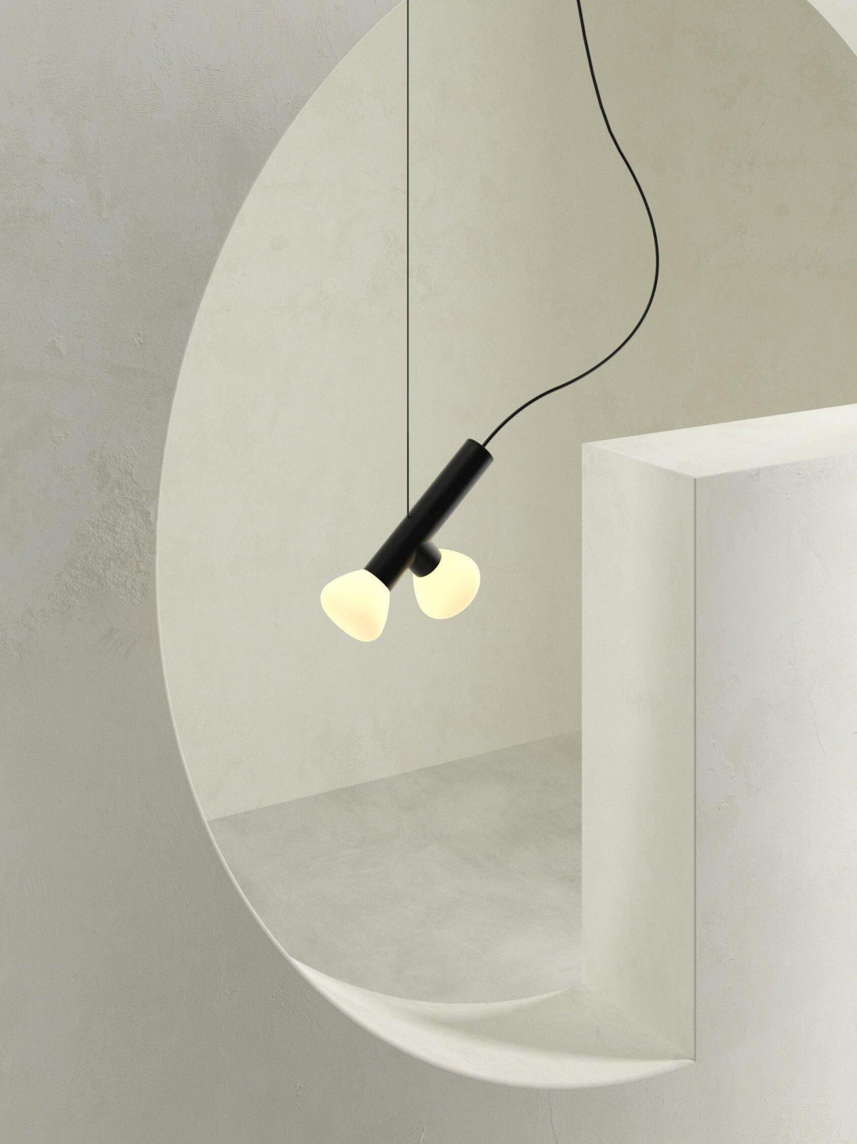 Black two-head pendant near a round interior opening