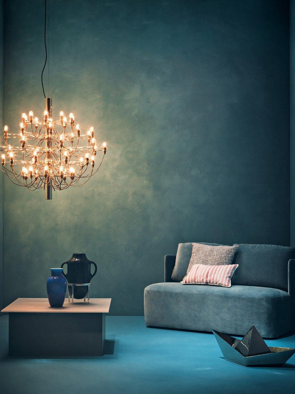 Gold-toned chandelier against a dark blue wall