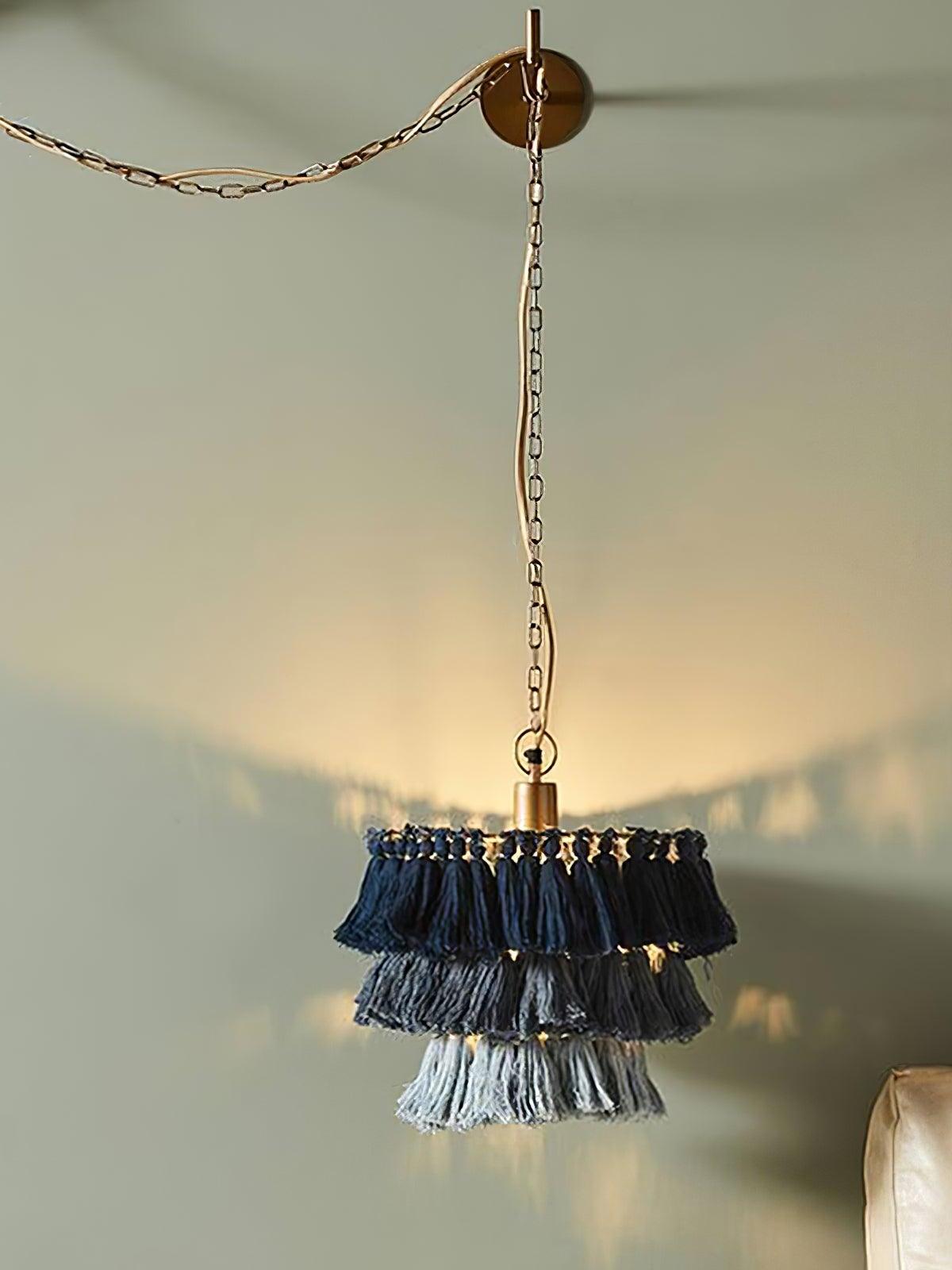 Blue tiered shade hanging from a wall-mounted chain