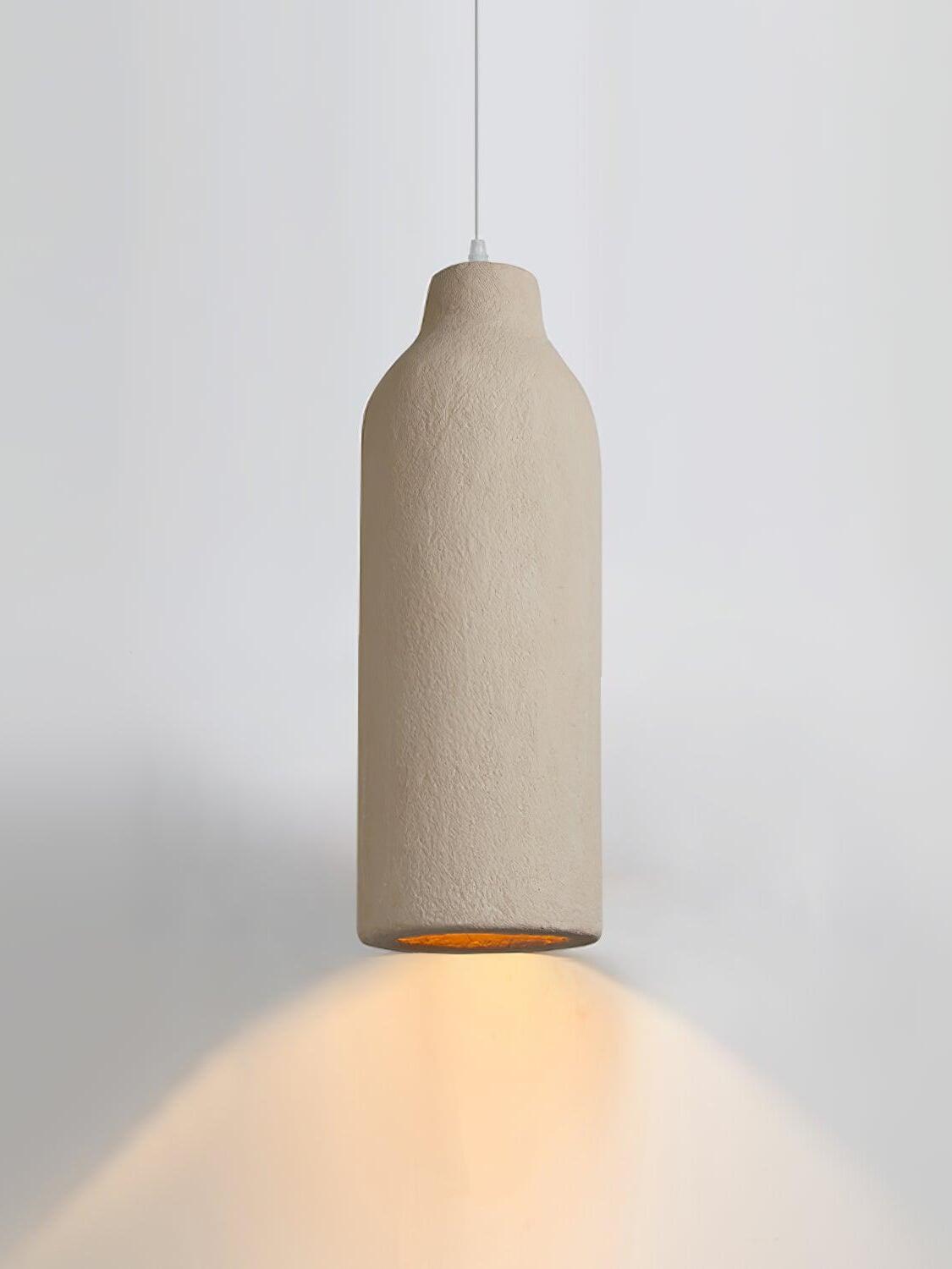 Lit narrow bottle-shaped pendant with short neck, grainy surface and warm light below on white