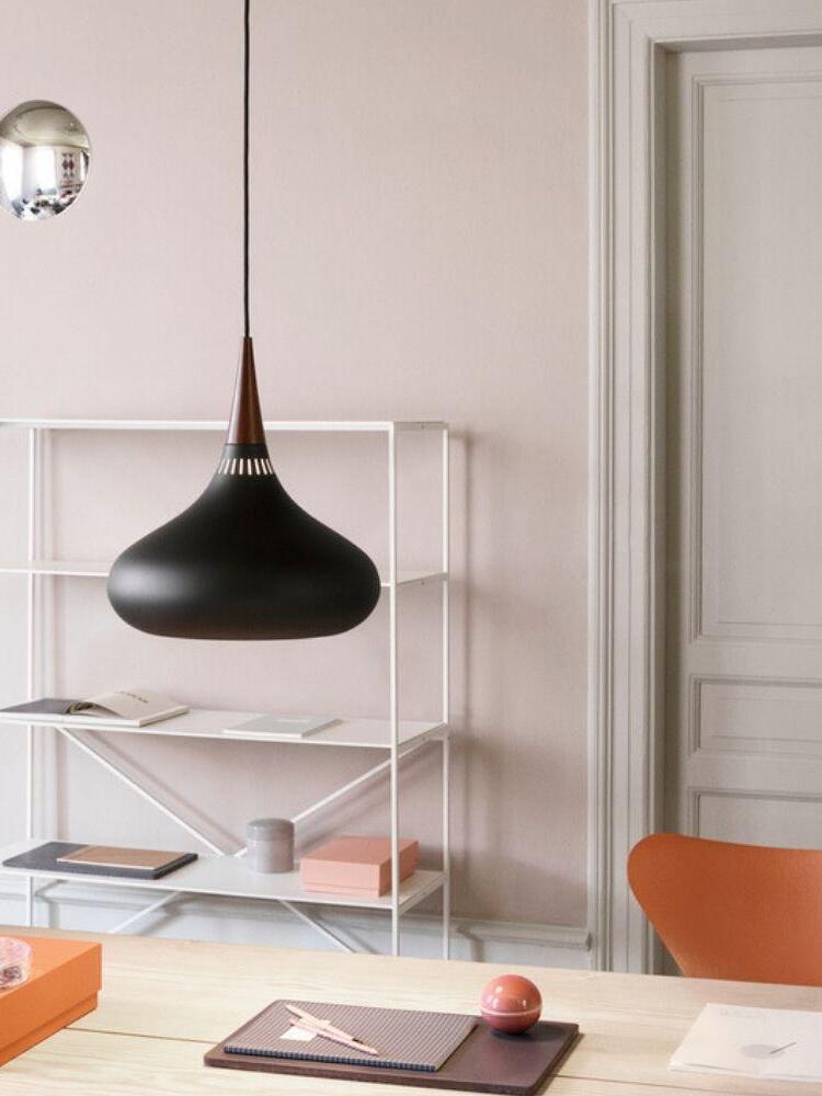 Black rounded pendant over a bright desk